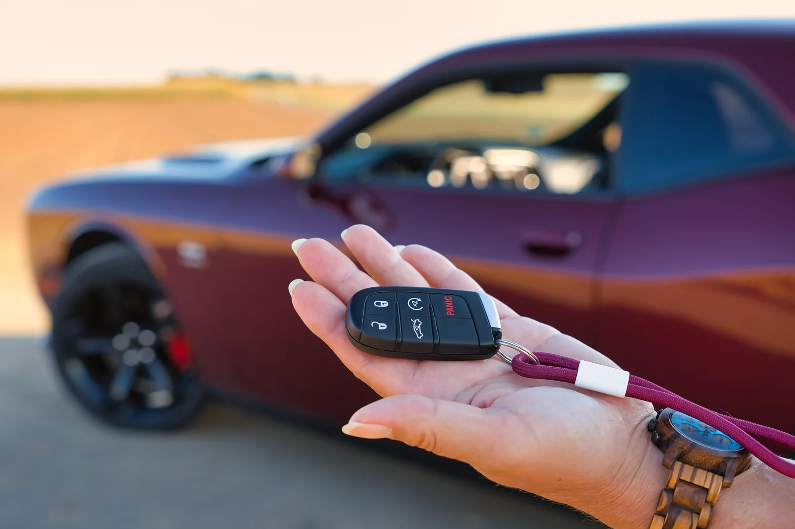 Car key fob in hand near vehicle